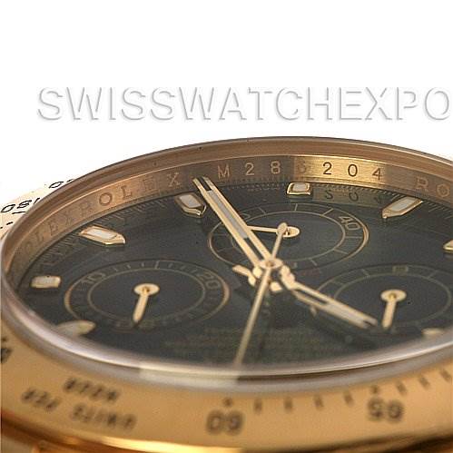 This is a close-up angled view of the dial and bezels of a Rolex Daytona 116528 Men's Yellow Gold Black Dial 116528 Men's Yellow Gold Black Dial watch.