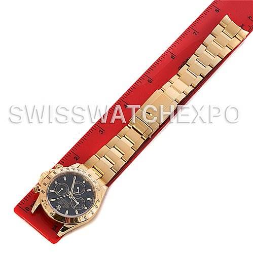 The image shows a top-down view of a Rolex Daytona 116528 Men's Yellow Gold Black Dial 116528 Men's Yellow Gold Black Dial watch, highlighting the face, bezel, and entire bracelet, placed next to a red ruler.