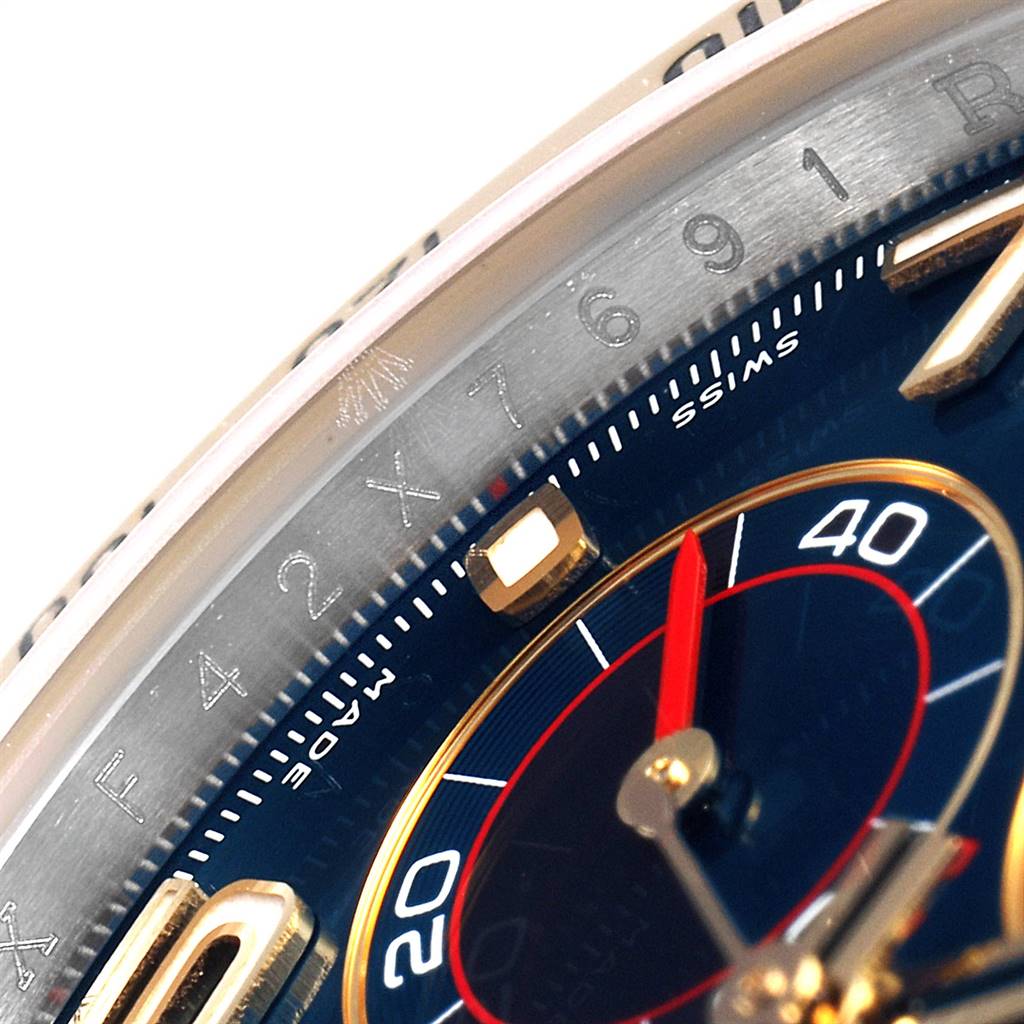 This close-up image shows the bezel and part of the dial of a Rolex Daytona 116523 Men's Steel and Gold (two tone) Blue Dial 116523 Men's Steel and Gold (two tone) Blue Dial watch.