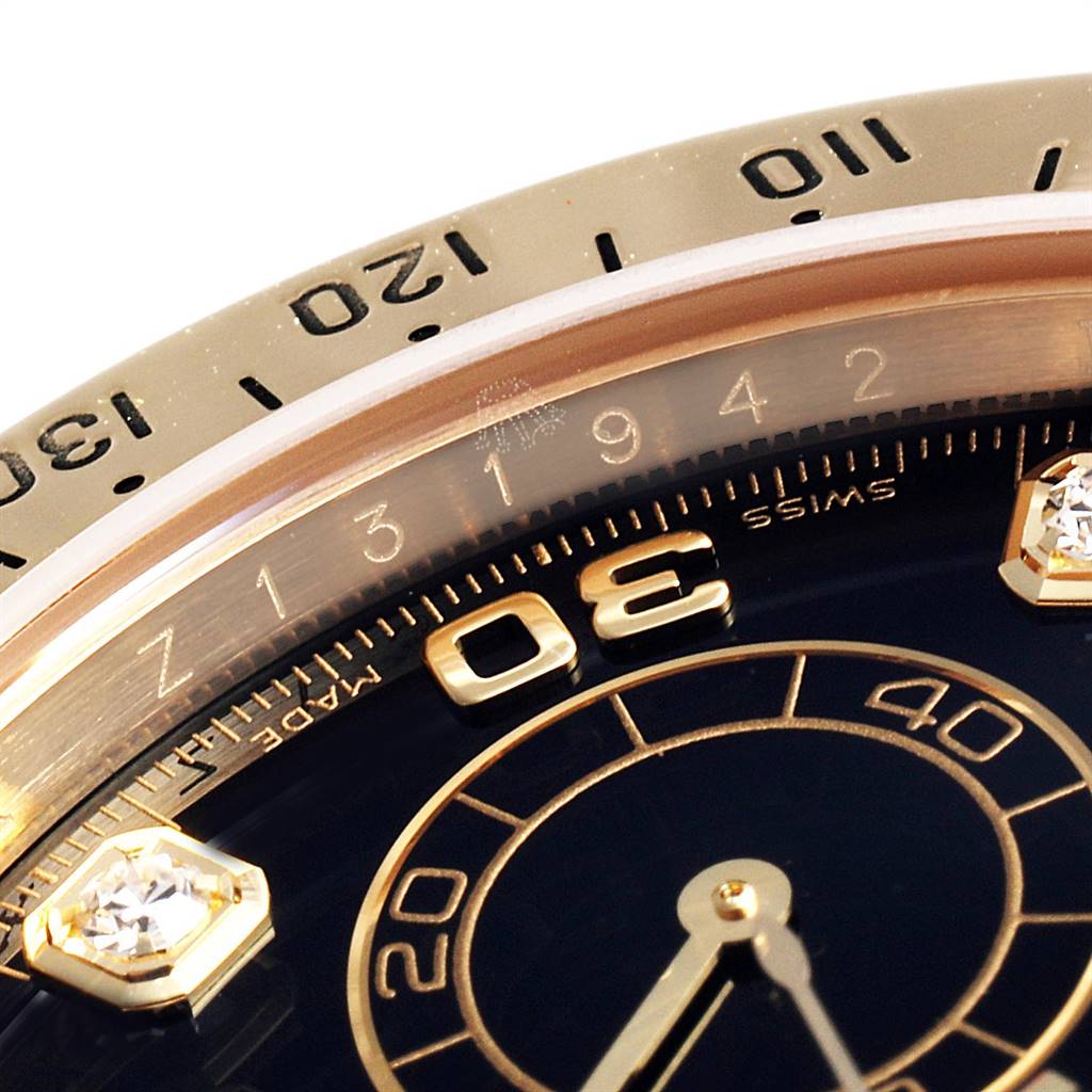 This close-up image shows the bezel, part of the dial, and markers of a Rolex Daytona 116528 Men's Yellow Gold Black Dial 116528 Men's Yellow Gold Black Dial watch.