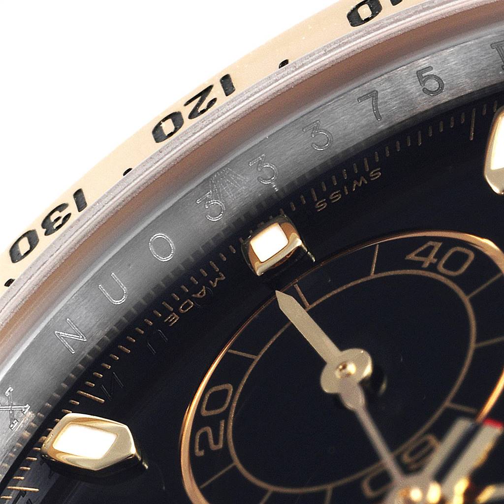 The image shows a close-up of the dial and bezel of a Rolex Daytona 116523 Men's Steel and Gold (two tone) Black Dial 116523 Men's Steel and Gold (two tone) Black Dial watch, highlighting the markings and part of the minute hand.
