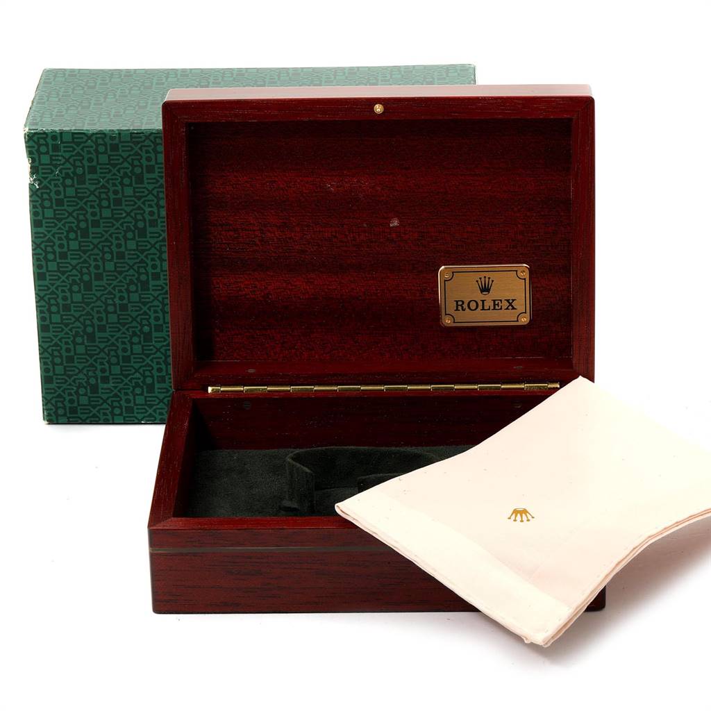 The image shows an open Rolex Daytona 16528 Men's Yellow Gold Black Dial 16528 Men's Yellow Gold Black Dial box with a green outer box and a white cleaning cloth.