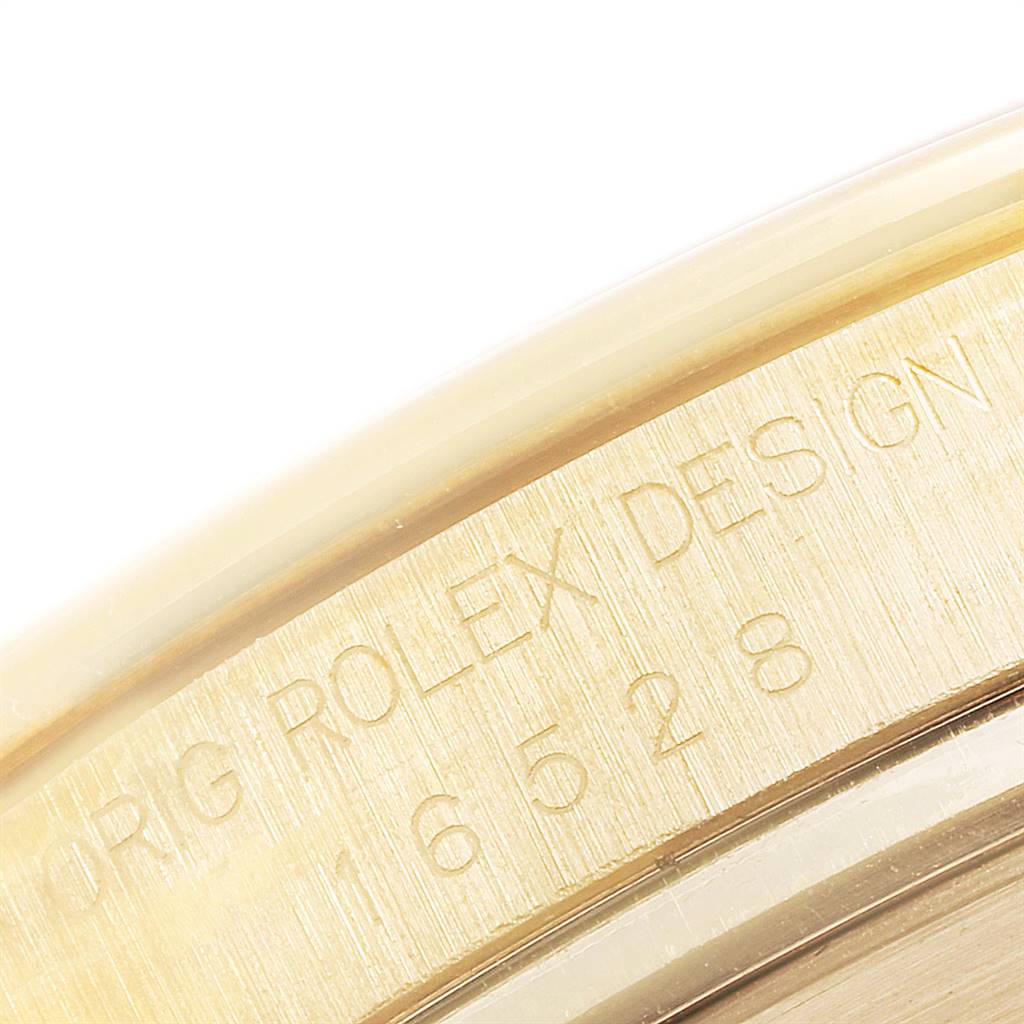 This close-up image shows the engraving on the side of the case of a Rolex Daytona 16528 Men's Yellow Gold White Dial 16528 Men's Yellow Gold White Dial watch.