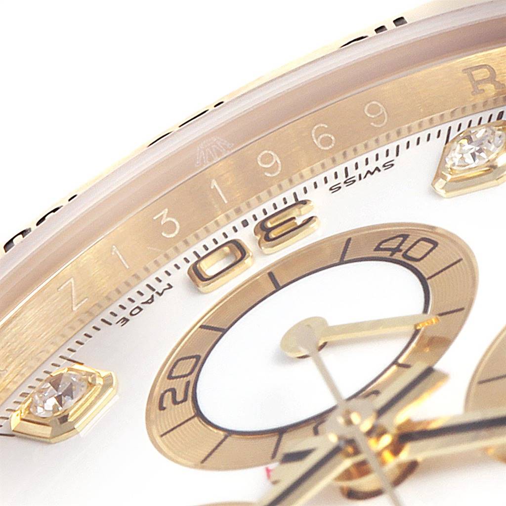 This close-up image of a Rolex Daytona 116528 Men's Yellow Gold White Dial 116528 Men's Yellow Gold White Dial watch shows part of the dial, minute markers, and chronograph sub-dial at an angle.