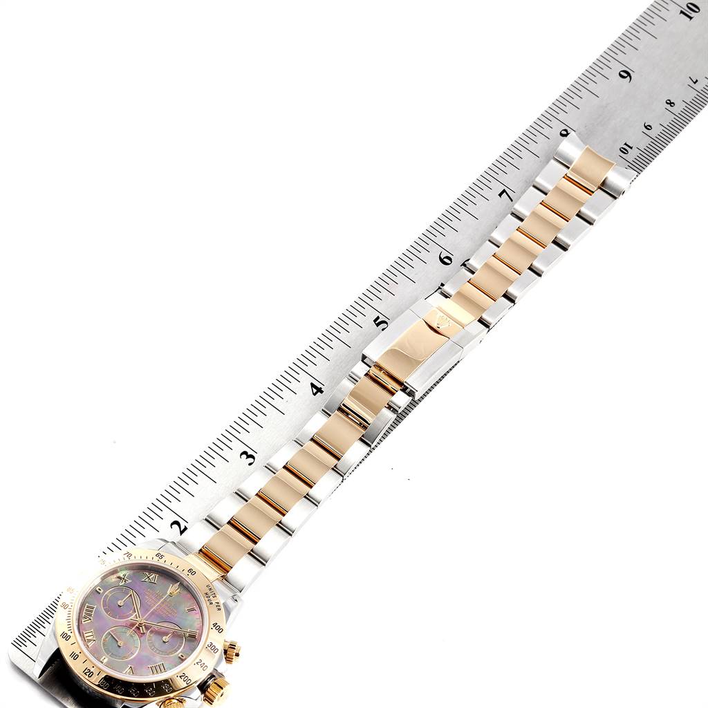 The image shows a Rolex Daytona 116523 Men's Steel and Gold (two tone) Mother of Pearl Dial 116523 Men's Steel and Gold (two tone) Mother of Pearl Dial watch laid flat, highlighting the bracelet and partially the watch face, positioned next to a ruler for scale.
