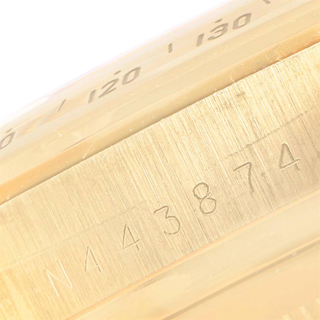 This close-up image of a Rolex Daytona 16528 Men
s Yellow Gold Champagne Dial 16528 Men
s Yellow Gold Champagne Dial watch shows the engraved serial number on the case and part of the bezel.