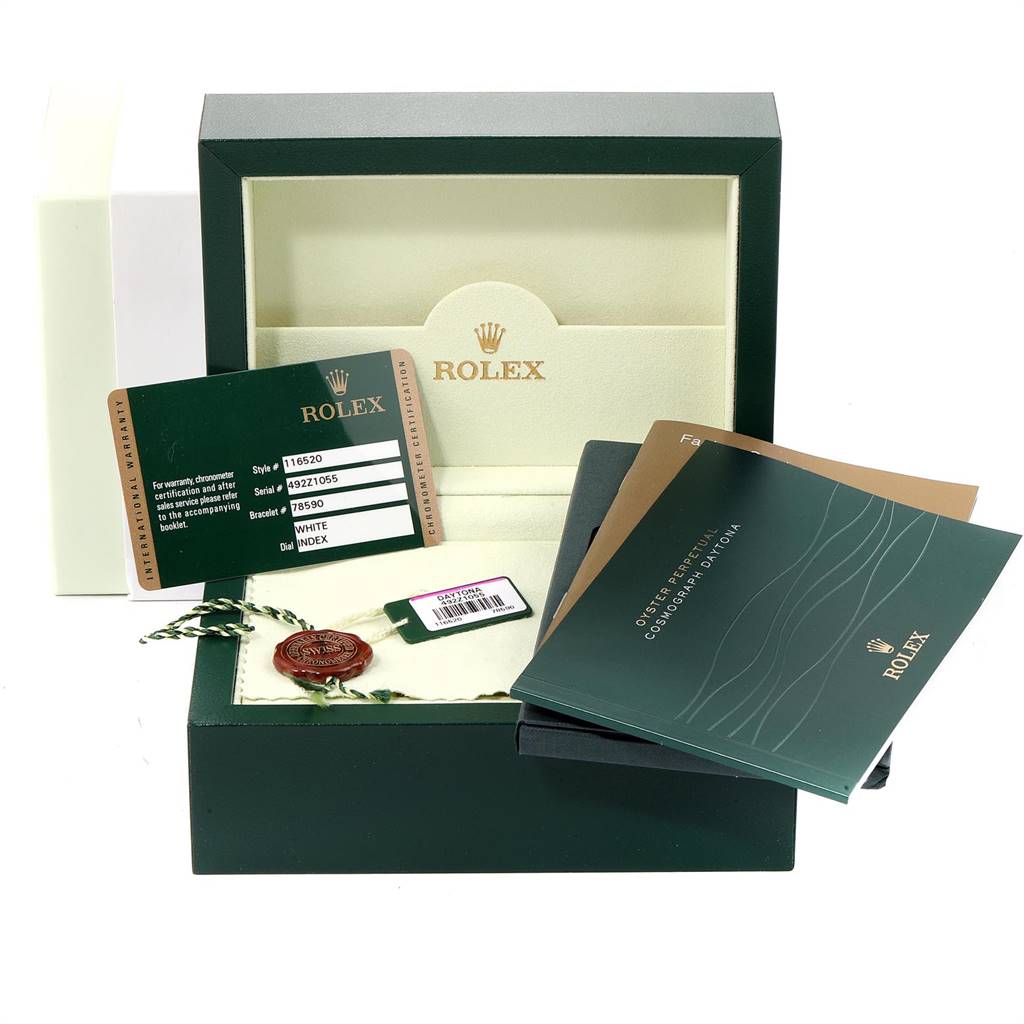 The image shows the accessories of a Rolex Daytona 116520 Men's Stainless Steel White Dial 116520 Men's Stainless Steel White Dial, including the box, warranty card, tags, and booklets.