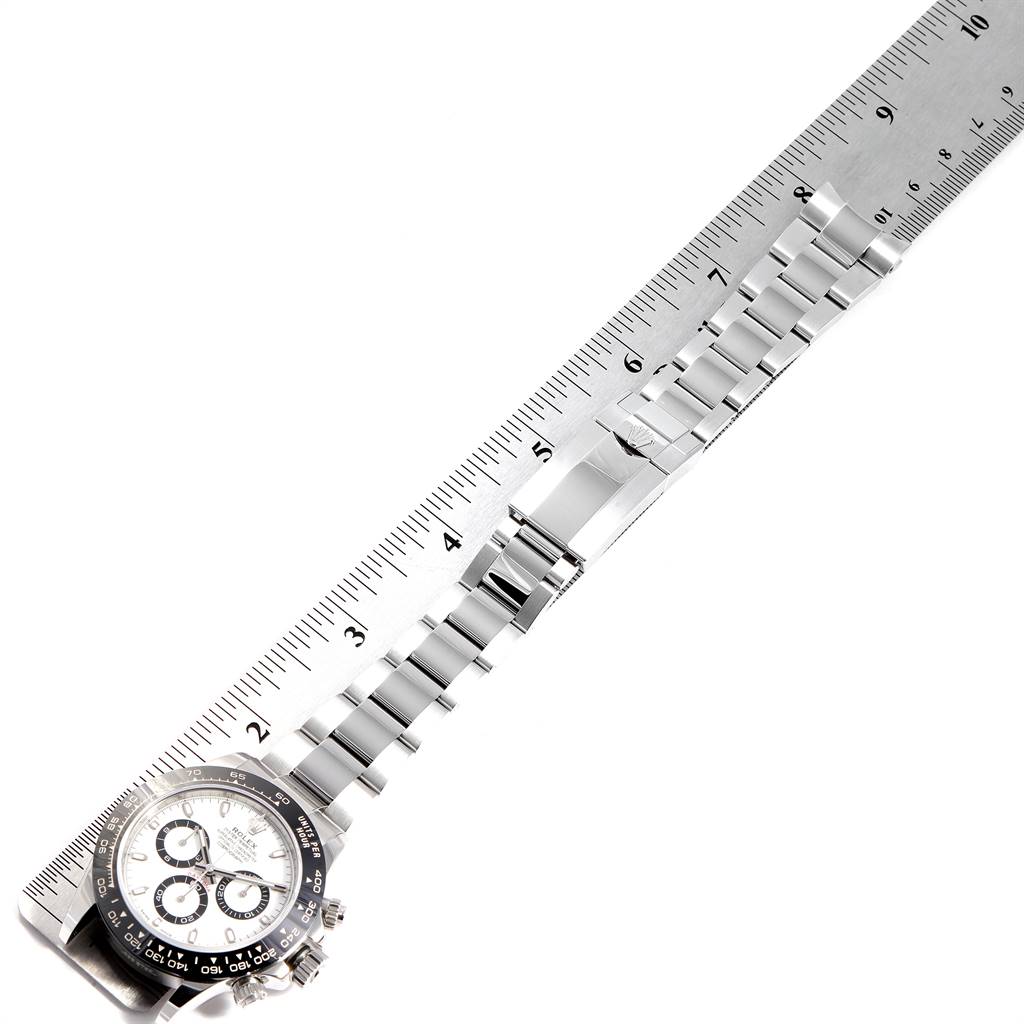 The image shows a Rolex Daytona 116500 Men's Stainless Steel White Dial 116500 Men's Stainless Steel White Dial watch laid flat with a metal bracelet, next to a ruler for scale.