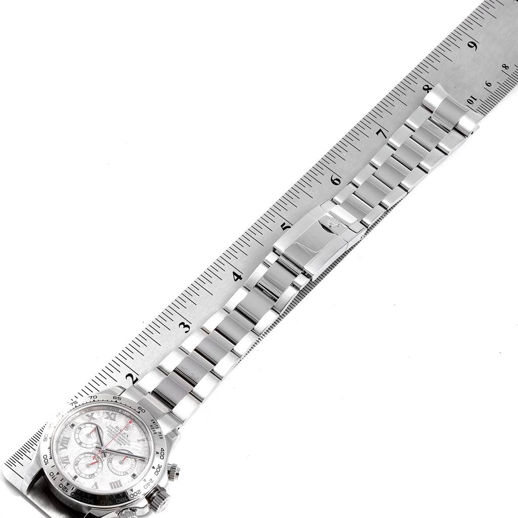 The image shows an angled view of a Rolex Daytona 116509 Men's White Gold Silver Dial 116509 Men's White Gold Silver Dial watch, highlighting its band and partial face next to a ruler.