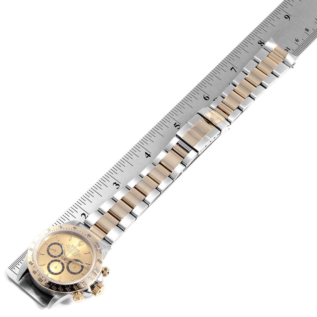 This image shows a Rolex Daytona 16523 Men's Steel and Gold (two tone) Champagne Dial 16523 Men's Steel and Gold (two tone) Champagne Dial watch laid flat with a ruler, displaying the face and entire metal bracelet.