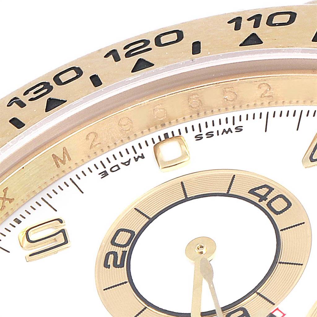 The image shows a close-up of the dial and bezel of a Rolex Daytona 116518 Men's Yellow Gold White Dial 116518 Men's Yellow Gold White Dial watch, featuring numerals and markings.