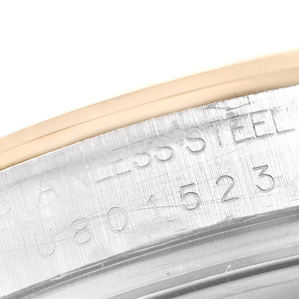 The image shows a close-up of the serial number and "STAINLESS STEEL" engraving on the caseback edge of a Rolex Daytona 16523 Men's Steel and Gold (two tone) Grey Dial 16523 Men's Steel and Gold (two tone) Grey Dial watch.