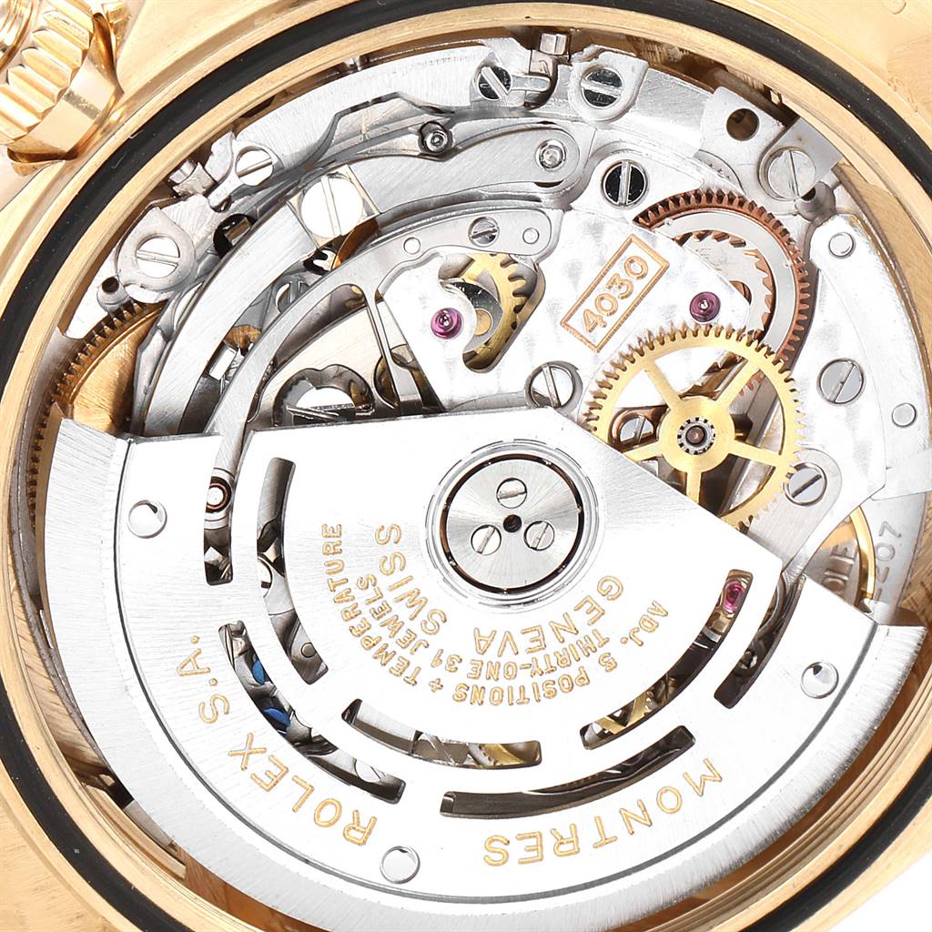 The image shows the intricate internal mechanism of a Rolex Daytona 16518 Men's Yellow Gold White Dial 16518 Men's Yellow Gold White Dial watch, viewed from the back, highlighting gears and engravings.
