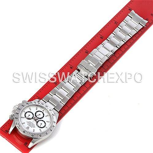 The image shows a Rolex Daytona 16520 Men's Stainless Steel White Dial 16520 Men's Stainless Steel White Dial watch laid flat, showcasing the entire face, bezel, and bracelet on a red ruler.