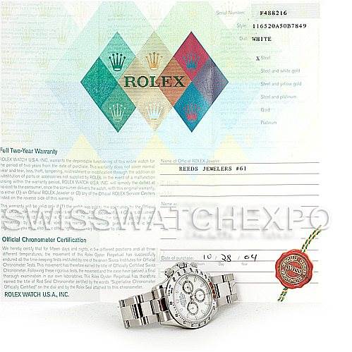 The image shows a Rolex Daytona 116520 Men's Stainless Steel White Dial 116520 Men's Stainless Steel White Dial watch placed in front of its official chronometer certification and warranty papers.