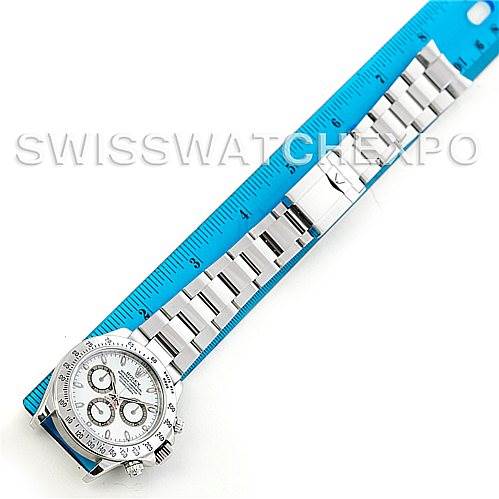 This image shows a top view of a Rolex Daytona 116520 Men's Stainless Steel White Dial 116520 Men's Stainless Steel White Dial watch placed next to a blue ruler, highlighting the watch's face and bracelet.