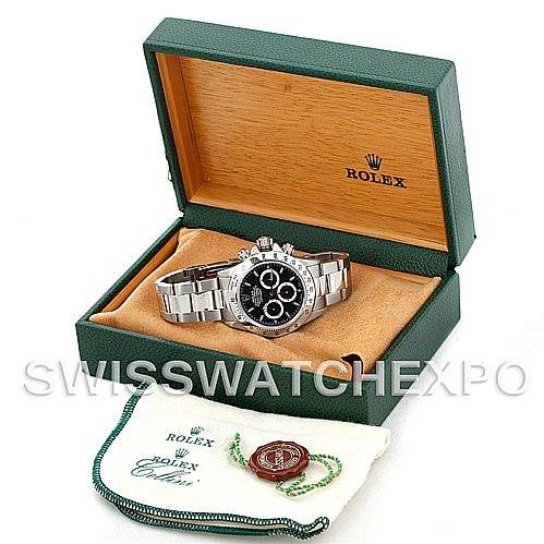 The image shows a Rolex Daytona 16520 Men's Stainless Steel Black Dial 16520 Men's Stainless Steel Black Dial watch at a front angle inside its open green box, with accessories like tags and a cloth pouch in front.
