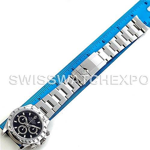 This image shows a Rolex Daytona 116520 Men's Stainless Steel Black Dial 116520 Men's Stainless Steel Black Dial watch laid flat next to a ruler, displaying the watch face and bracelet fully extended.