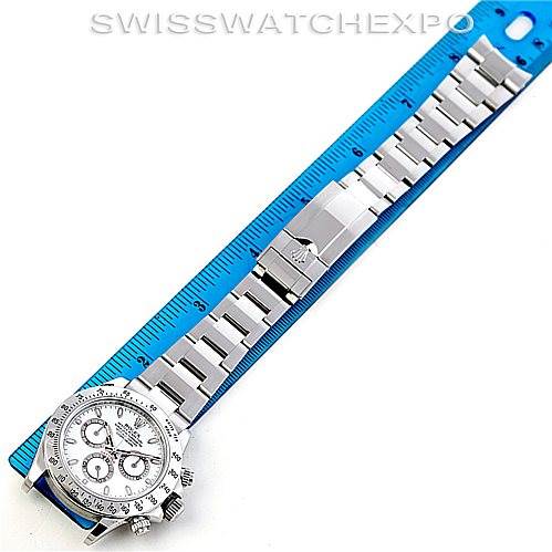 The image shows a Rolex Daytona 116520 Men's Stainless Steel White Dial 116520 Men's Stainless Steel White Dial watch laid flat with the dial and bracelet visible, alongside a blue ruler for scale.