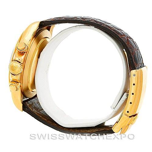 This image shows a side view of a Rolex Daytona 16518 Men's Yellow Gold White Dial 16518 Men's Yellow Gold White Dial watch, highlighting the crown, pushers, and leather strap with a gold buckle.