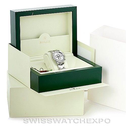 The image shows a Rolex Daytona 116520 Men's Stainless Steel White Dial 116520 Men's Stainless Steel White Dial watch angled inside its open green and white presentation box with additional packaging.