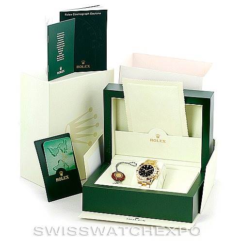 The image shows a Rolex Daytona 116528 Men's Yellow Gold Black Dial 116528 Men's Yellow Gold Black Dial watch in its box, along with accessories including manuals, a warranty card, and a cleaning cloth.
