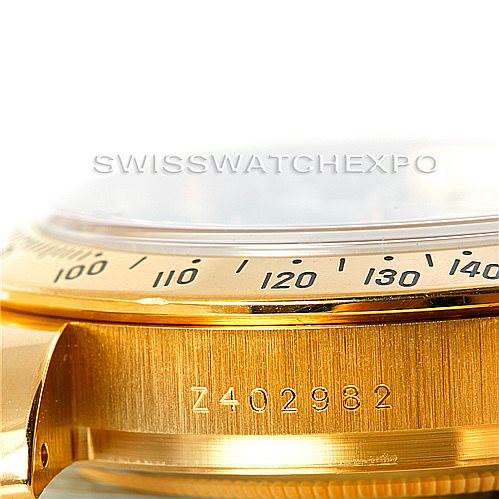 The image shows a close-up of the side of the Rolex Daytona 116528 Men's Yellow Gold Black Dial 116528 Men's Yellow Gold Black Dial, highlighting its serial number and part of the bezel.