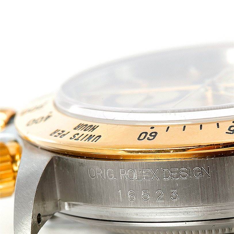 This image shows a close-up of the bezel, crown, and part of the case of the Rolex Daytona 16523 Men's Steel and Gold (two tone) Champagne Dial 16523 Men's Steel and Gold (two tone) Champagne Dial model, highlighting its engraving and design details.