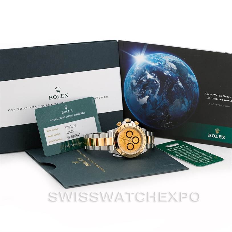 The image shows a Rolex Daytona 16523 Men's Steel and Gold (two tone) Champagne Dial 16523 Men's Steel and Gold (two tone) Champagne Dial watch with its accessories, including the warranty card and documentation, displayed at an angle.