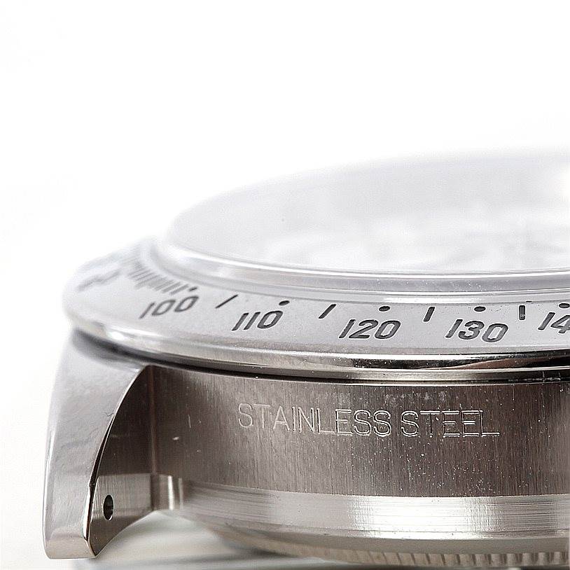 The image shows a close-up of the bezel and stainless steel case of a Rolex Daytona 116520 Men's Stainless Steel White Dial 116520 Men's Stainless Steel White Dial watch at a side angle.