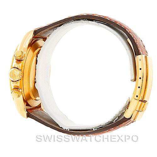 This side view image of a Rolex Daytona 16518 Men's Yellow Gold White Dial 16518 Men's Yellow Gold White Dial watch displays the crown, pushers, and a brown leather strap with the buckle.