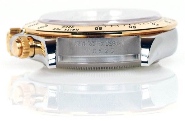 The image shows a side view of a Rolex Daytona 116523 Men's Stainless Steel Black Dial 116523 Men's Stainless Steel Black Dial watch case, highlighting the crown, bezel, and part of the casing with engravings.