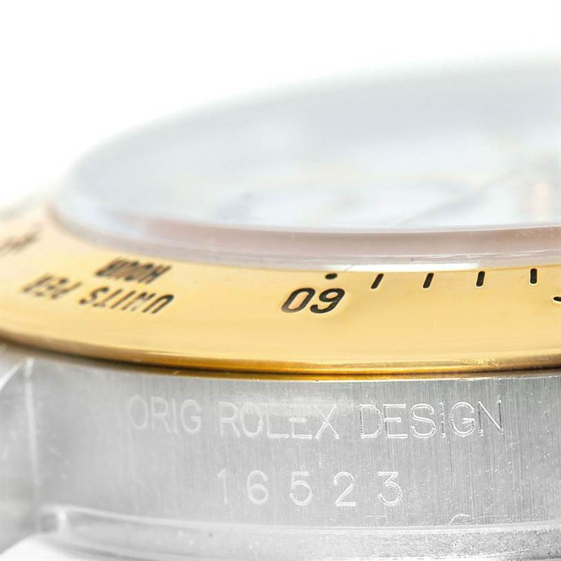 This image shows a close-up side view of a Rolex Daytona 16523 Men's Steel and Gold (two tone) White Dial 16523 Men's Steel and Gold (two tone) White Dial watch, highlighting the bezel and the engraved model number, 16523.