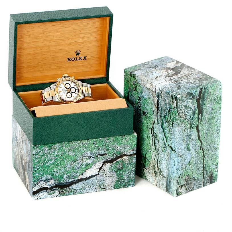 The Rolex Daytona 16523 Men's Steel and Gold (two tone) White Dial 16523 Men's Steel and Gold (two tone) White Dial watch is shown at a front angle in an open green and wood box, with the outer packaging visible beside it.