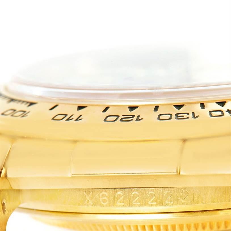 This image shows a close-up side angle of the Rolex Daytona 16518 Men's Yellow Gold White Dial 16518 Men's Yellow Gold White Dial watch, highlighting the bezel and part of the case with markings.