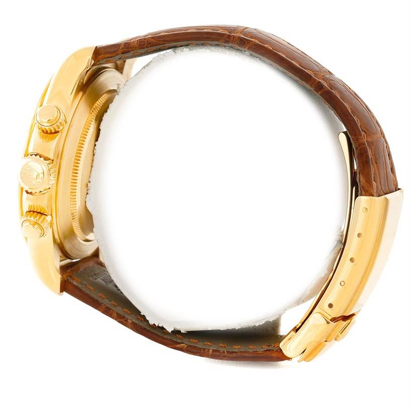 The Rolex Daytona 16518 Men's Yellow Gold White Dial 16518 Men's Yellow Gold White Dial watch is shown from the side, highlighting the case, crown, pushers, and brown leather strap.