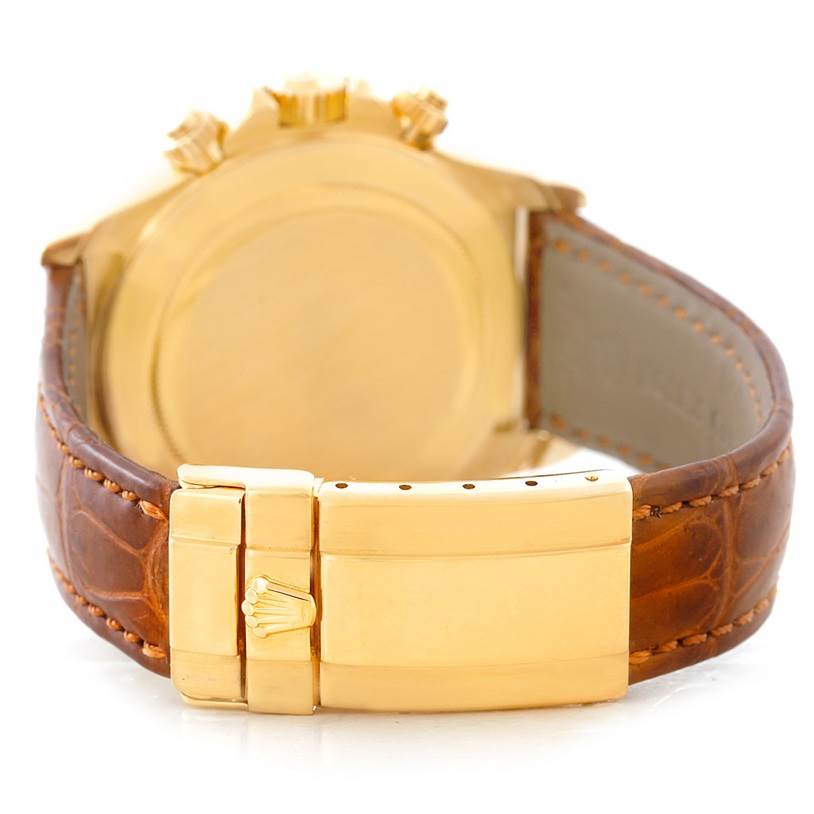 The image shows the rear view of a Rolex Daytona 16518 Men's Yellow Gold White Dial 16518 Men's Yellow Gold White Dial watch, highlighting its gold clasp and brown leather strap.