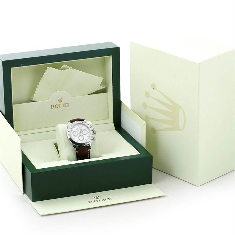 The image shows a Rolex Daytona 116520 Men's Stainless Steel White Dial 116520 Men's Stainless Steel White Dial watch in its open box, with a green and cream interior and a cleaning cloth.