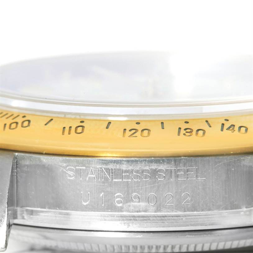 This close-up image shows the side of a Rolex Daytona 16523 Men's Steel and Gold (two tone) White Dial 16523 Men's Steel and Gold (two tone) White Dial watch, highlighting the bezel and case with serial number engraving.
