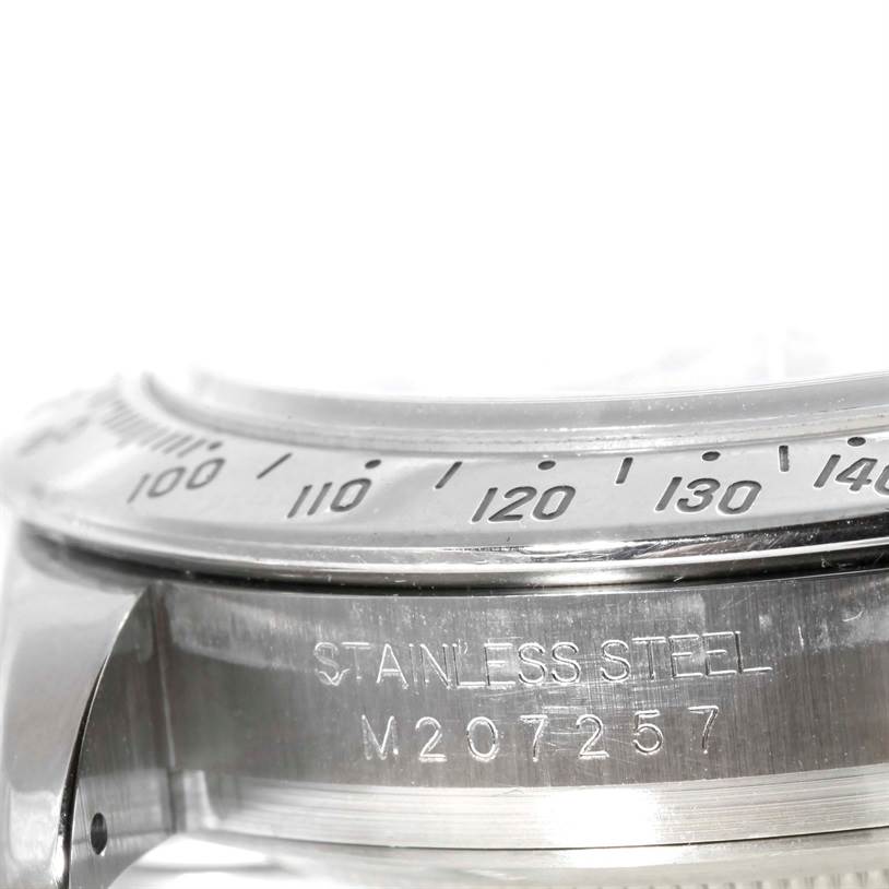 The image shows a close-up of the stainless steel bezel and engraving on the Rolex Daytona 116520 Men's Stainless Steel White Dial 116520 Men's Stainless Steel White Dial model watch.