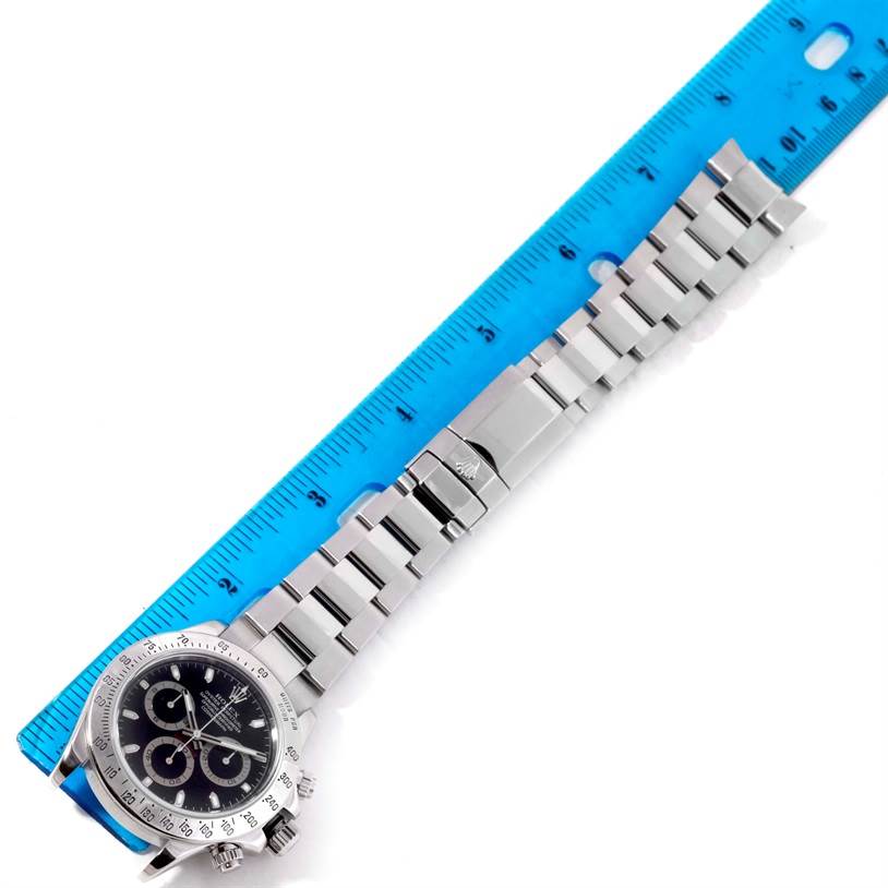 The image shows a full-length view of a Rolex Daytona 116520 Men's Stainless Steel Black Dial 116520 Men's Stainless Steel Black Dial watch, including the face, bezel, and bracelet, measured against a ruler.