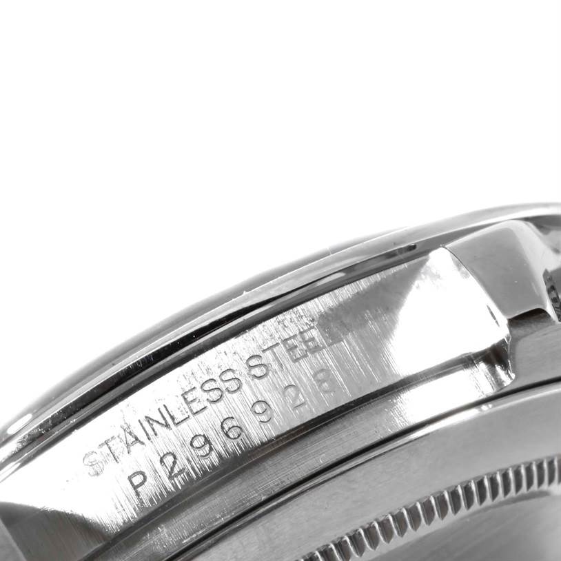 The image shows a close-up of the side engraving and part of the bezel of a Rolex Daytona 116520 Men's Stainless Steel Black Dial 116520 Men's Stainless Steel Black Dial model watch.