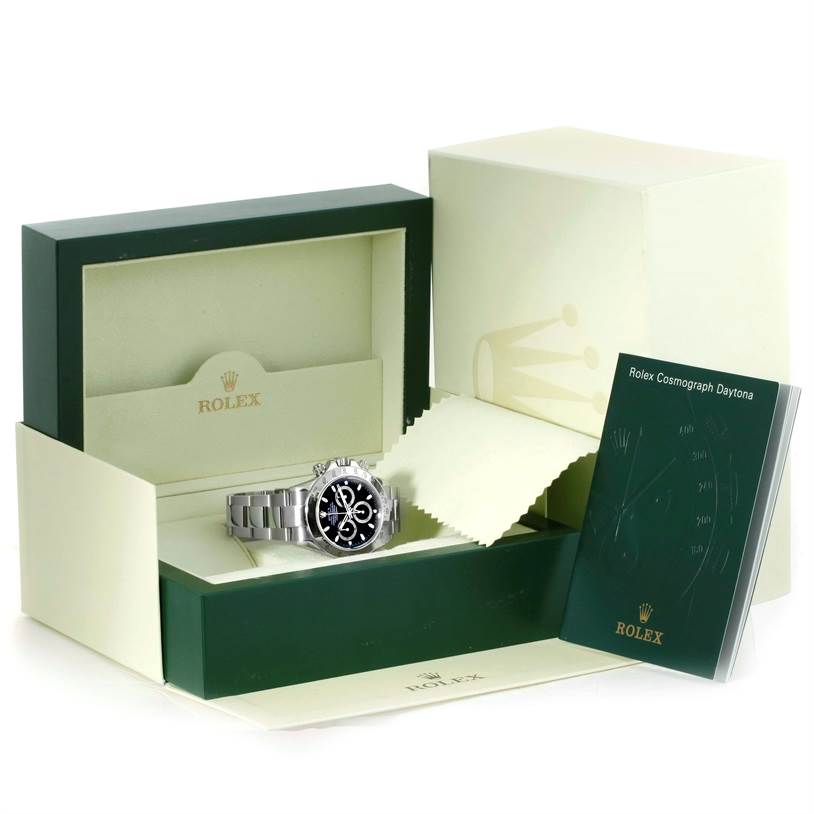 The image shows a Rolex Daytona 116520 Men's Stainless Steel Black Dial 116520 Men's Stainless Steel Black Dial watch at an angled view, placed within its open box, along with a manual and packaging.