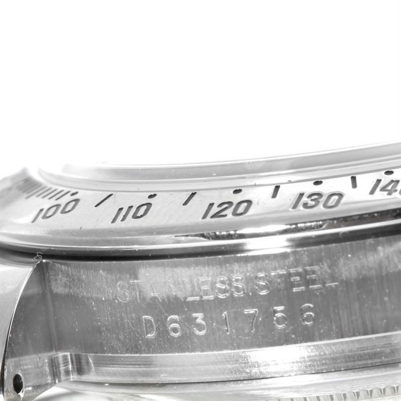 This close-up image shows the bezel and part of the case of a Rolex Daytona 116520 Men's Stainless Steel White Dial 116520 Men's Stainless Steel White Dial watch with engraved numerals.