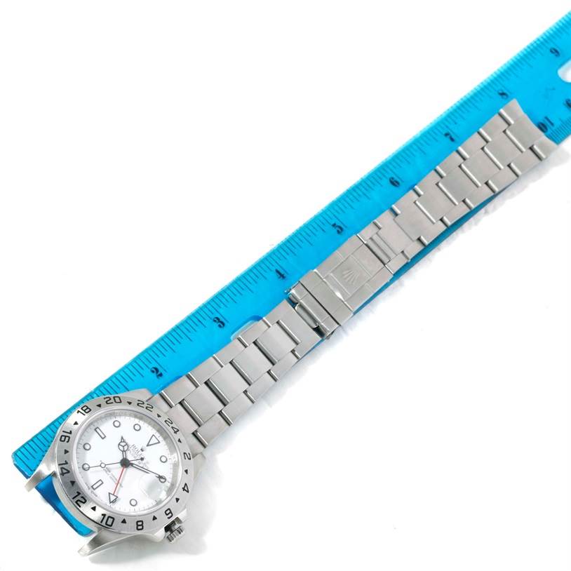 The image shows the Rolex Explorer 16570 Men's Stainless Steel White Dial 16570 Men's Stainless Steel White Dial watch model laid out horizontally alongside a blue ruler.