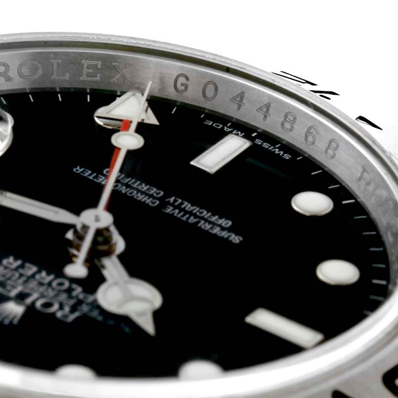 This close-up image of the Rolex Explorer 16570 Men's Stainless Steel Black Dial 16570 Men's Stainless Steel Black Dial watch shows part of the bezel, dial, and serial number engraving.