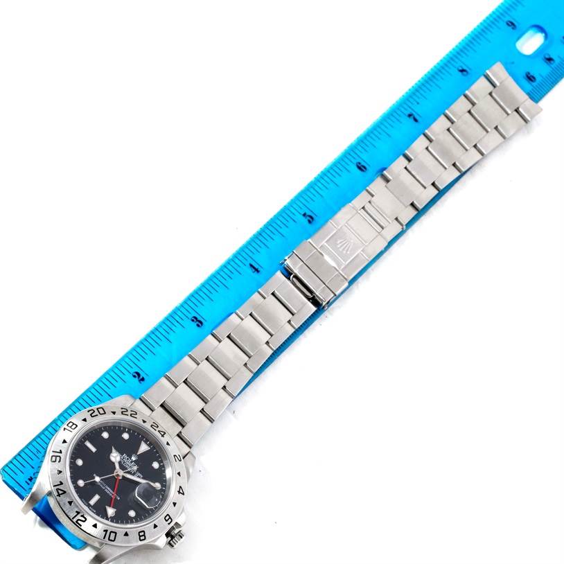 The image shows the entire Rolex Explorer 16570 Men's Stainless Steel Black Dial 16570 Men's Stainless Steel Black Dial watch laid flat next to a blue ruler for scale.