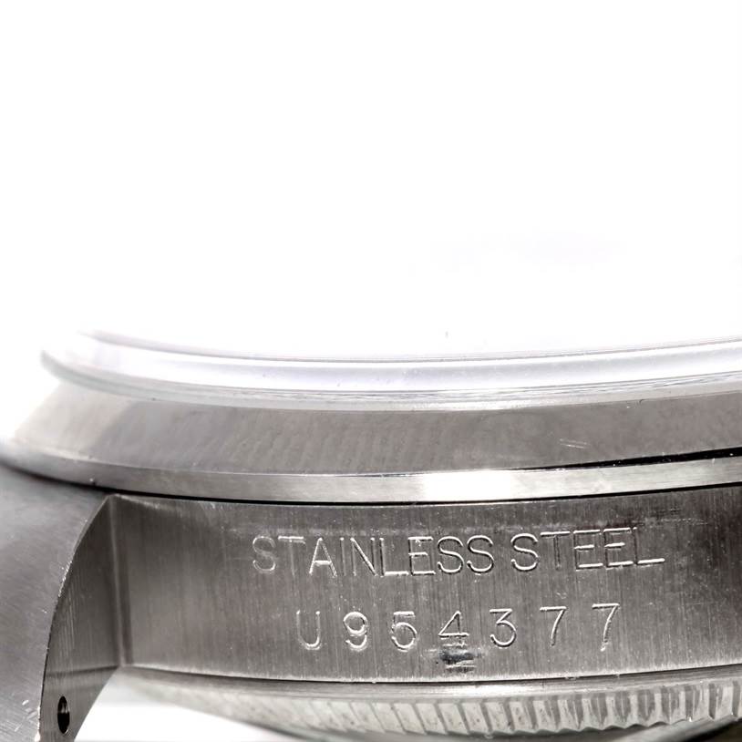 The image shows a close-up of the case side of the Rolex Explorer 14270 Men's Stainless Steel Black Dial 14270 Men's Stainless Steel Black Dial model, highlighting the serial number and "STAINLESS STEEL" engraving.