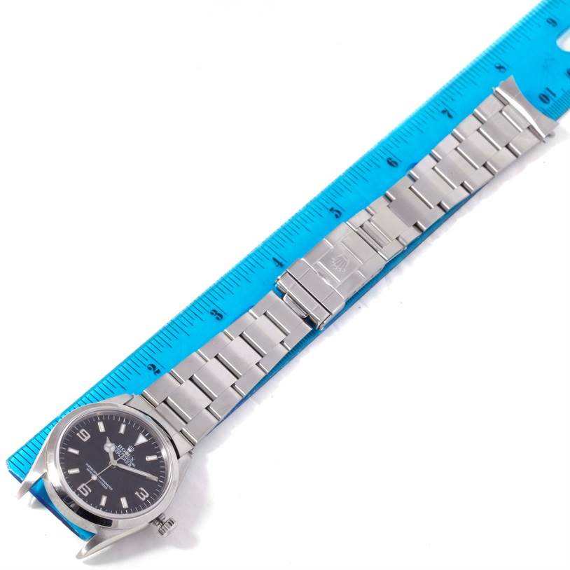 The image shows a Rolex Explorer 14270 Men's Stainless Steel Black Dial 14270 Men's Stainless Steel Black Dial watch laid flat beside a ruler, displaying the full wristband and watch face.