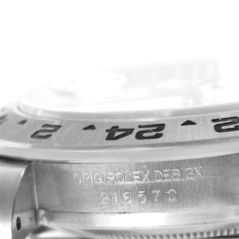 The photo shows a side angle close-up of a Rolex Explorer 216570 Men
s Stainless Steel White Dial 216570 Men
s Stainless Steel White Dial watch, highlighting the bezel and engraved model number.